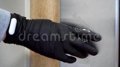 在冠状病毒和<strong>传染病</strong>流行期间，一个戴着黑色防护手套的人按下电梯按钮。